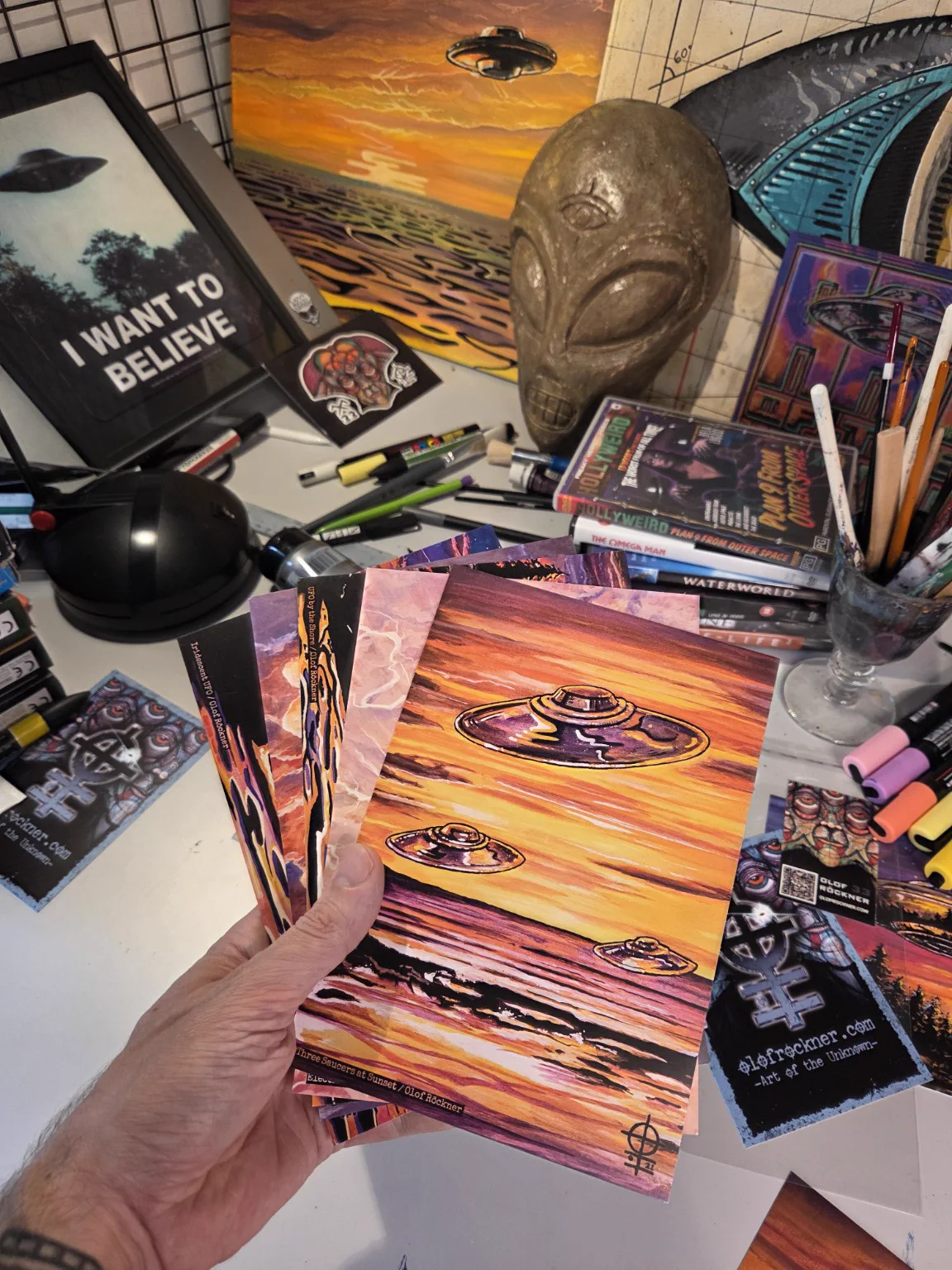 Olof Röckner holding UFO print cards in his Stockholm studio